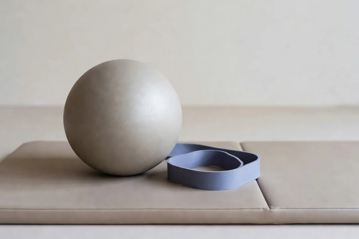 Bola de pilates e faixa elástica sobre o tapete